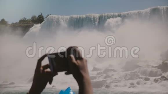 慢动作特写人类双手拍摄智能手机照片史诗尼亚加拉瀑布瀑布全景在一个晴朗的夏日视频的预览图