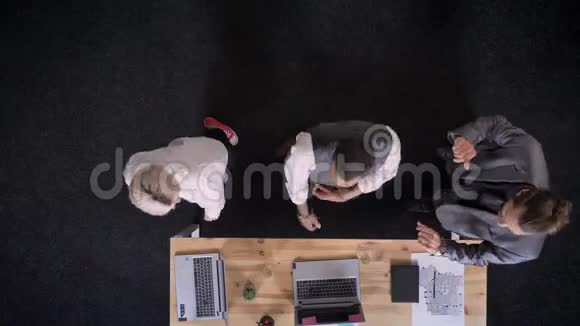 公司里三个兴高采烈的牧师们正在桌子旁跳舞手提电脑戴着香槟的眼镜视频的预览图