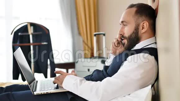不满的男人用智能手机指着屏幕PC说话讨论问题视频的预览图