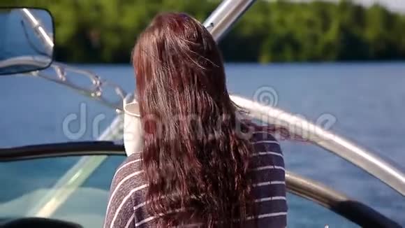 迷人的年轻黑发女人一边在湖上的船上喝咖啡视频的预览图