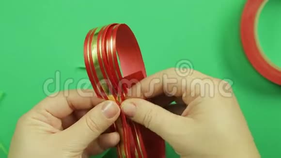 女人手塑造空白的红色丝带用来做礼物蝴蝶结绿色背景视频的预览图