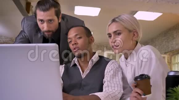 三个不同民族的工人在笔记本电脑上讨论思想笑同事观念沟通观念视频的预览图