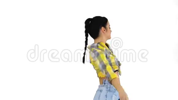 华丽可爱的女孩穿着牛仔裤短裤运动鞋在白色背景上跳舞视频的预览图