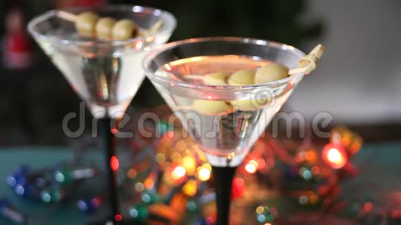 两杯带橄榄的马提尼酒和背景上带波克的淡花圈视频的预览图