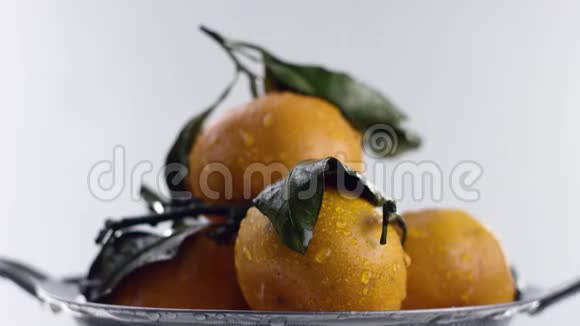 在橘子上注入强烈的水射流在视频的末尾水停止了白色的背景视频的预览图