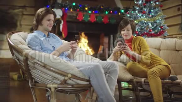男人和女人在圣诞夜用智能手机笑视频的预览图
