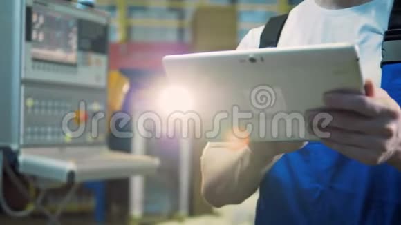 工厂里一个男工人手中的平板电脑视频的预览图