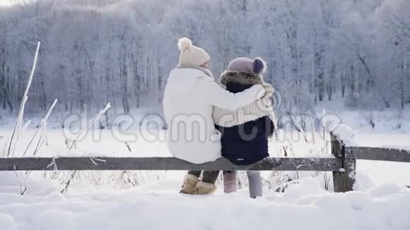 一家人穿着温暖的衣服拥抱着欣赏冬天的风景视频的预览图