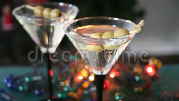 两杯带橄榄的马提尼酒和背景上带波克的淡花圈视频的预览图