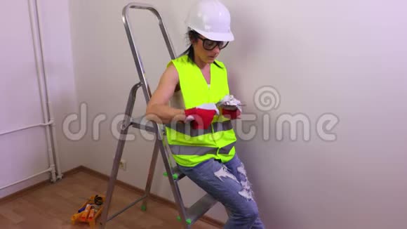 女建筑工人坐在阶梯上视频的预览图
