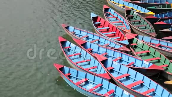 水上有很多古老的木色船湖上蓝红绿黄的船视频的预览图
