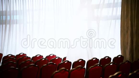 一个商业大厅大厅里一把空的红椅子窗帘在风中展开视频的预览图