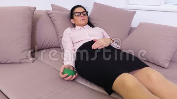 疲惫的女人躺在沙发上捏着压力球视频的预览图