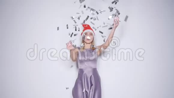 圣诞老人礼帽上的快乐年轻女子彩纸掉落视频的预览图