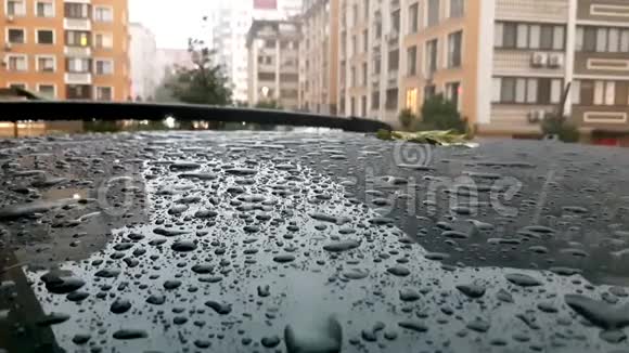 停在路上的黑色汽车屋顶上的雨滴下雨天视频的预览图