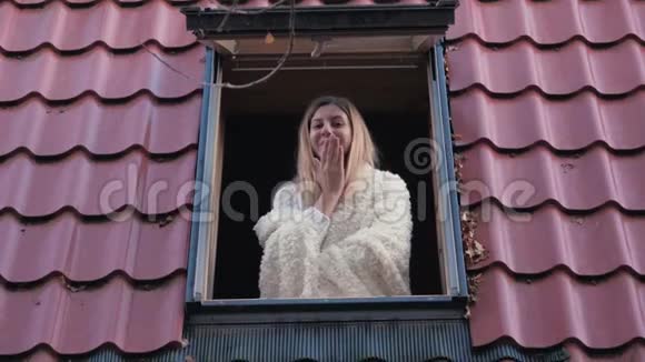幸福的微笑女人在窗前看着镜头亲吻视频的预览图