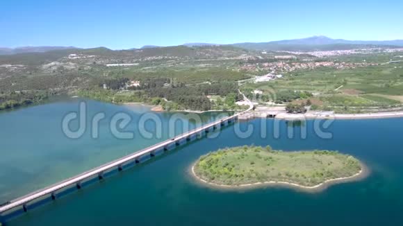 空中俯瞰宽阔的河流在平原上有一座有庄稼的汽车桥阿利亚克莫纳斯河希腊维利亚用无人机前进视频的预览图