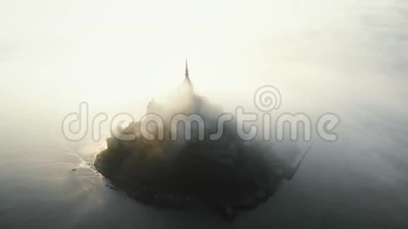 史诗般的空中拍摄圣米歇尔山在高潮日出古岛城堡覆盖阳光雾流在诺曼底视频的预览图