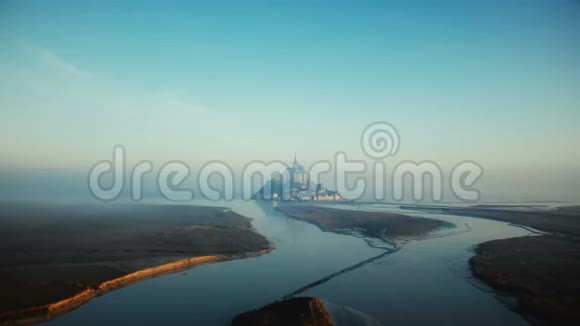 在史诗般的日出高潮中向雾蒙蒙圣米歇尔飞去这是法国标志性的岛屿城堡视频的预览图