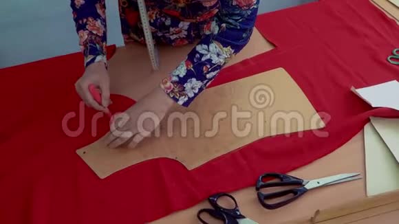 女裁缝在衣服的花纹部分铺在布料上视频的预览图