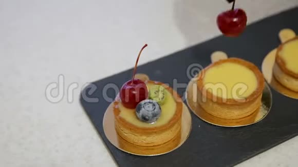 靠近厨师用樱桃和蓝莓装饰一个新鲜的烘焙蛋糕视频的预览图