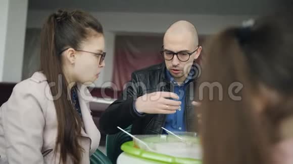 父亲和两个女儿在咖啡馆吃午饭视频的预览图