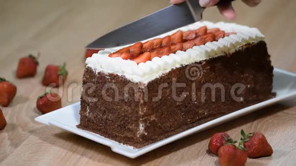 女性手切蛋糕与生奶油和草莓水果视频的预览图