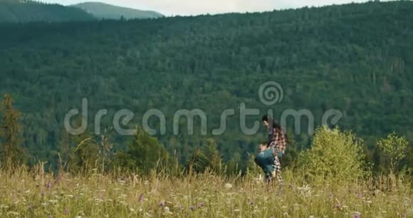 洛维斯托鲁山男人背着幸福的女人走过田野在山上的某个地方快乐视频的预览图