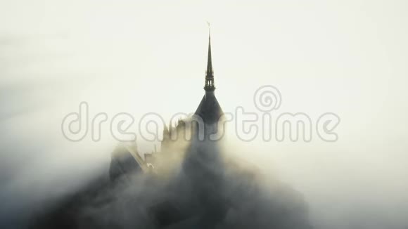 在诺曼底史诗般的日出期间雾云在著名雄伟的圣米歇尔山要塞堡上空流动视频的预览图