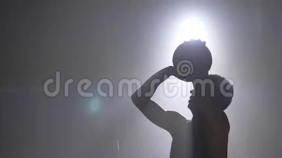 篮球运动员剪影练习做扣篮和投掷球背景泛光灯视频的预览图