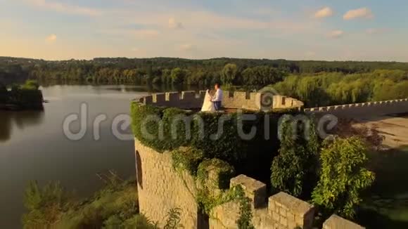 城堡附近的新郎新娘的鸟瞰图视频的预览图