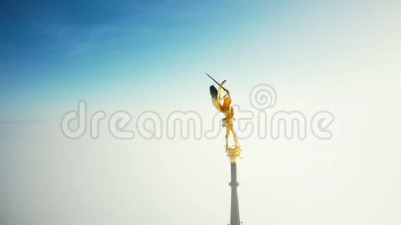 无人机从史诗般的金色天使雕像上飞过圣米歇尔山城堡尖塔在天空的云层之上视频的预览图