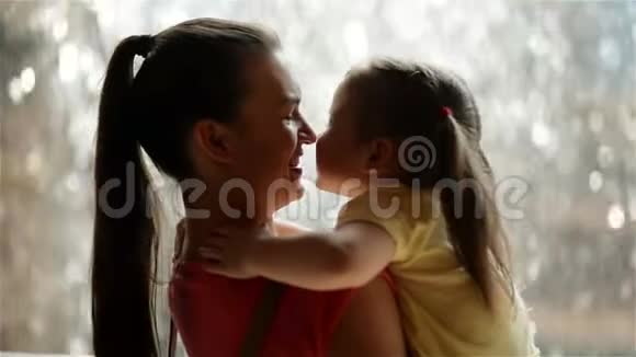母亲和她的女儿在拥抱雨在背景上他们玩得很开心因为今天是母亲节视频的预览图