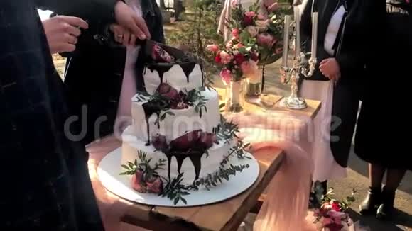 婚礼上的新娘和新郎切了一个漂亮的三层蛋糕分发给客人视频的预览图