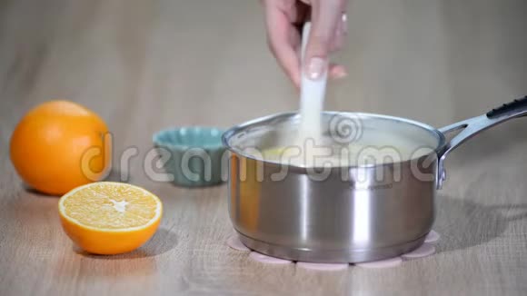 女性手在平底锅中搅拌奶油冻视频的预览图