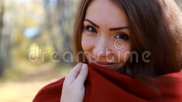 一个穿毯子的特写女人的肖像晴朗的秋日寒冷的天气视频的预览图