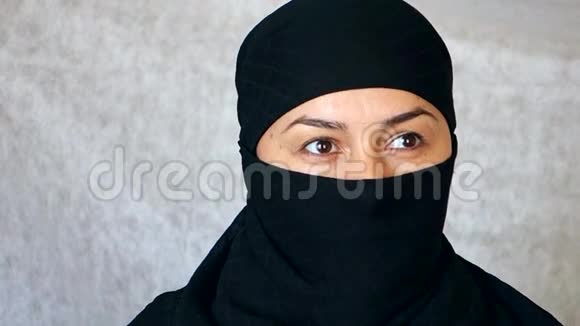 一个美丽的阿拉伯女孩的肖像一个穿着头巾的伊斯兰妇女看着镜头视频的预览图