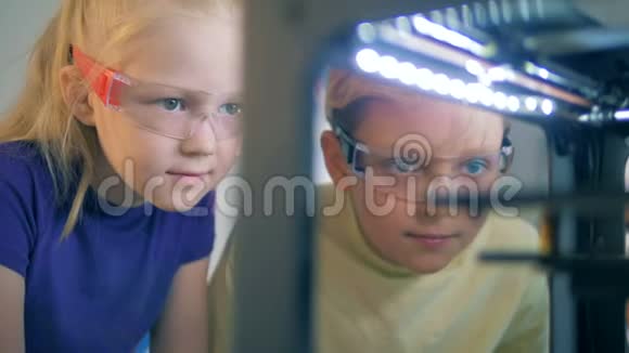两个孩子仔细观察印刷机制视频的预览图