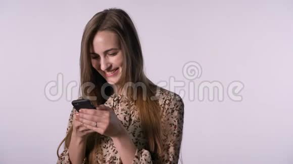 年轻快乐的女人正在智能手机上阅读信息交流理念白色背景视频的预览图