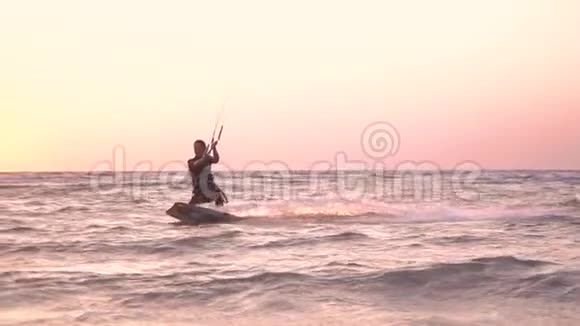 一个穿着潜水服的女孩在黎明时从事风筝冲浪动作缓慢视频的预览图