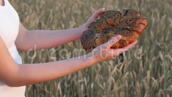 女孩看着面包微笑麦田背景上的香面包收获和农业视频的预览图