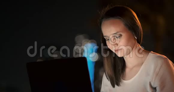 女开发商晚上坐在公园里看着笔记本电脑屏幕写代码视频的预览图