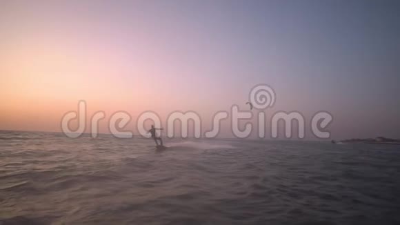 慢镜头拍摄黎明时一群放风筝的人乘着海浪视频的预览图