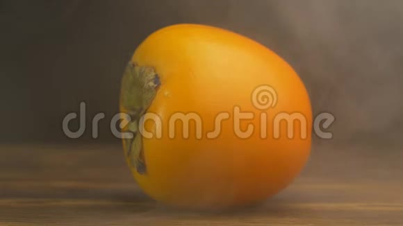 新鲜的柿子在黑色的背景下吹出凉爽和新鲜蒸发特写缓慢的莫视频的预览图