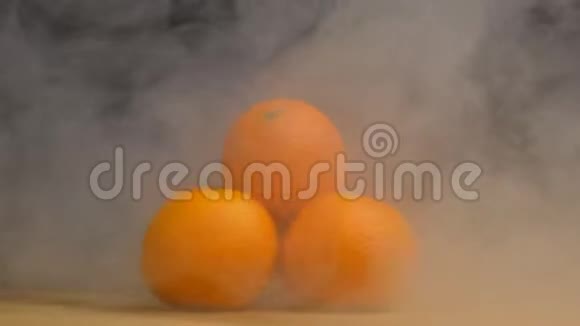 一堆新鲜多汁的橘子在黑色的背景上旋转从中吹出凉爽和蒸发关闭视频的预览图