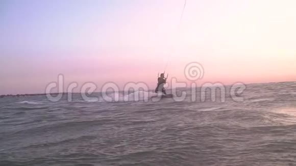 一个女孩在海上风筝在黎明时冲浪慢动作泄漏视频的预览图