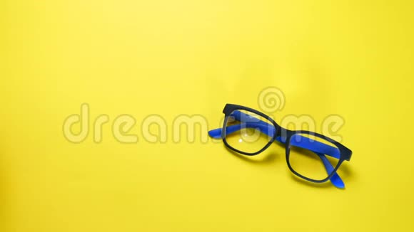 人类双手搜索在蓝色塑料框架中找到并拿走眼镜在黄色背景上视频的预览图