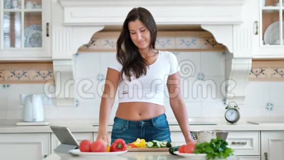 英俊的年轻女子在厨房做饭用叉子尝试或吃新鲜美味的食材视频的预览图