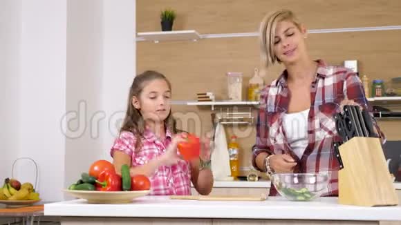 妈妈和女儿在厨房切了一个甜的红嘴视频的预览图