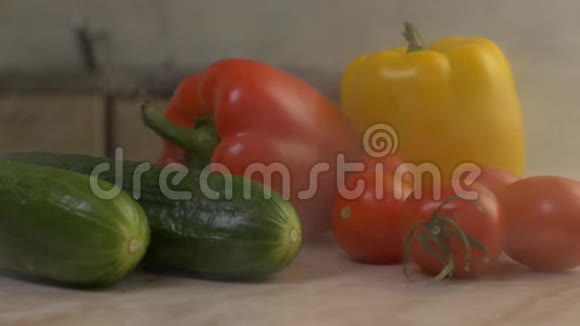 新鲜的蔬菜黄瓜西红柿和辣椒放在厨房的桌子上从桌子上吹来凉爽新鲜的香味很接近视频的预览图